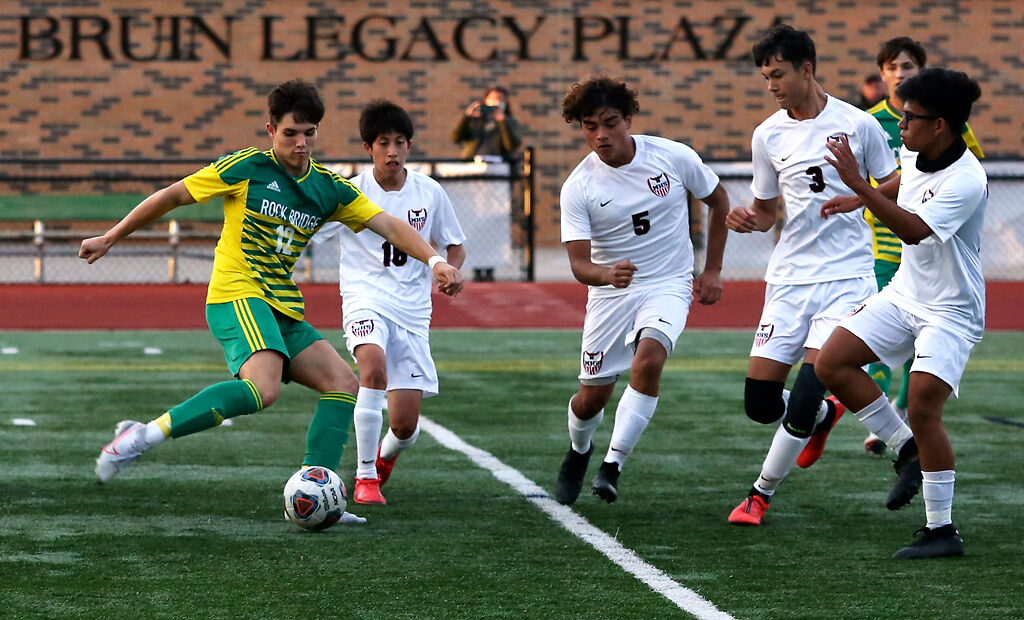 Rock Bridge senior Lucas Godon takes a shot as the Marshall defense attempts to block him